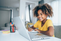 Young student watching lesson online and studying from home. Girl using laptop for online lessons. Homeschooling and distance learning concept.