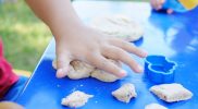 photo of child s hand playing clay